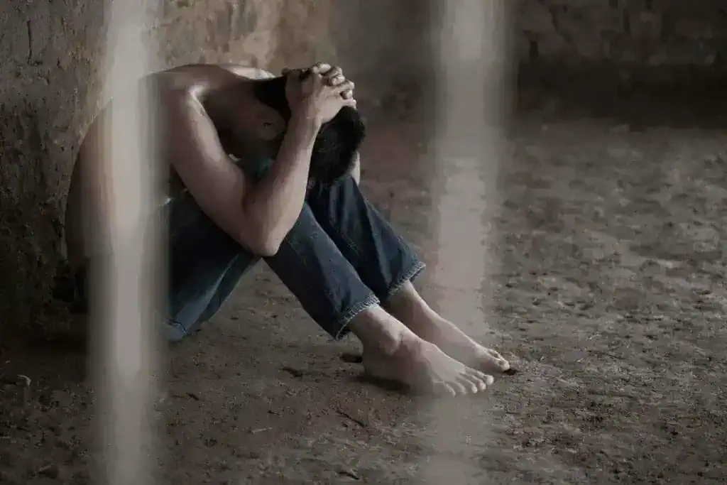 person sitting in distress showing effects of heroin addiction