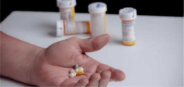person holding multiple prescription medications indicating misuse